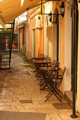 Plakat Cafe with metal chairs and tables In An Alley