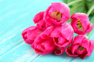 Beautiful tulips on color wooden background