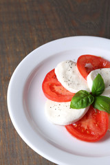 Caprese salad with mozarella cheese, tomatoes and basil