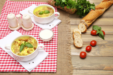 Tasty soup in saucepans on wooden table, close up
