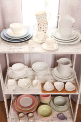 Fototapeta na wymiar Different tableware on shelf in the interior
