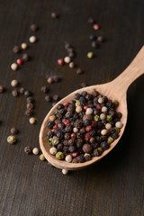 Spice pepper in spoon on wooden background
