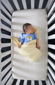 High Angle View Of A Newborn Baby Sleeping In A Crib