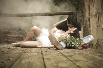 Young attractive couple kissing on wooden