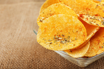 Homemade potato chips in glass bowl on table