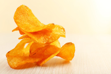Heap of homemade potato chips on light background