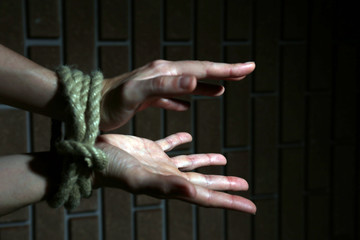 Tied hands on dark background