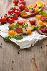 Tasty bruschetta with tomatoes, on old wooden table