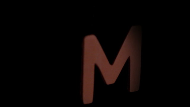 The letter m rising on black background
