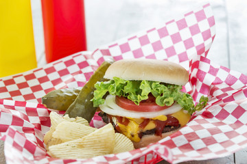 Loaded cheeseburger with potato chips at a picnic