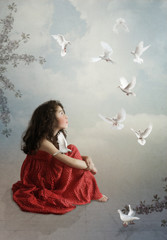 The little girl admires white pigeons