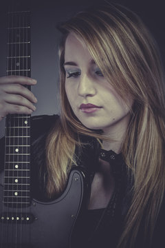 Heavy, Beautiful blond girl with black electric guitar