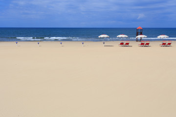 Obraz premium red umbrellas at beach with lifeguard location