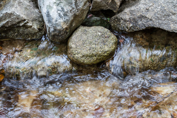 Fototapeta na wymiar Stones with water stream flowing between