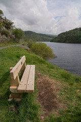 A wooden bench, set beside a picturesque lake