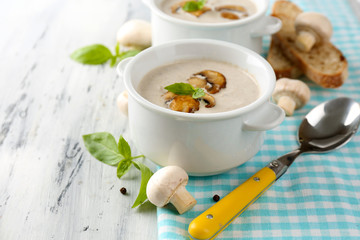 Mushroom soup in white pots, on napkin,  on wooden background