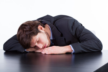 Obraz premium Tired businessman sleeping on table