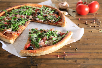 Pizza with arugula on color wooden background