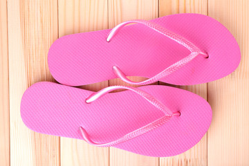 Bright flip-flops on wooden background