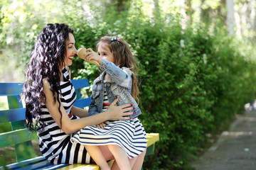 Happy mom and daughter. Walk in the green park