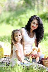 Happy mom and daughter. Picnic in the green park