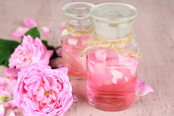Obraz na płótnie Canvas Rose oil in bottle on color wooden background