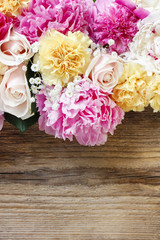 Stunning pink peonies, yellow carnations and roses on rustic