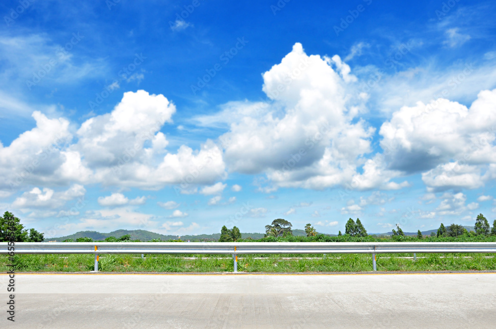 Wall mural Beautiful roadside view with green nature and cloudy blue sky  b