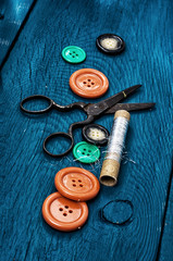 set of threads and buttons on the background of wood