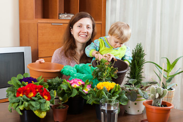 Woman  with baby with flowering plants in pots