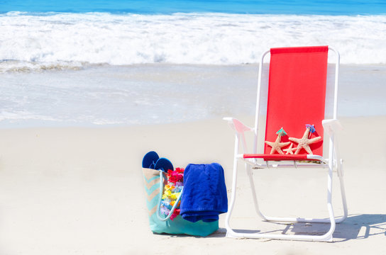 Beach chair with starfishes and bag by the ocean