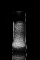 sea ​​salt on a black background in a bottle