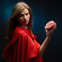 beautiful woman with red cloak holding pomegranate