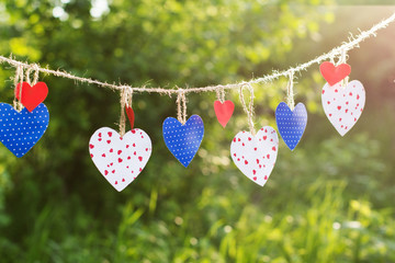 Colorful hearts hanging on green background
