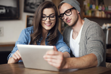 Young couple enjoying wireless internet at restaurant
