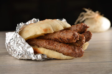 Traditional cevapcici with ajvar in the grilled roll