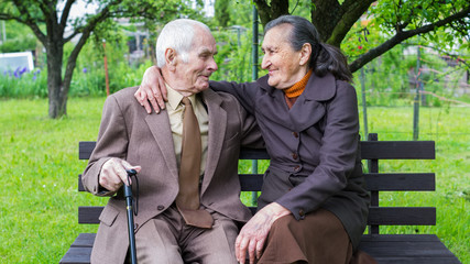 80 plus year old married couple posing in their garden.