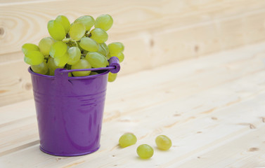 Green Grapes in a bucket on wooden background