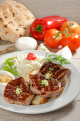 Grilled steaks on toast bread, served with onion and vegetable
