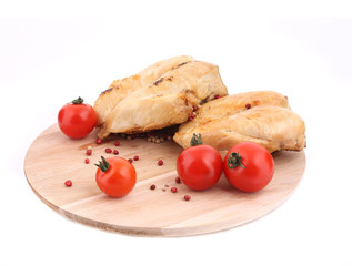 Grilled chicken with tomatoes on wood platter.
