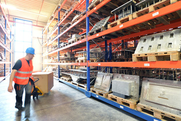 Lagerist mit Hubwagen in Lagerhaus // storeman in warehouse