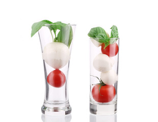Tomatoes and mozzarella balls in glass.