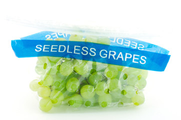 Seedless grapes in plastic bag isolated on white background.