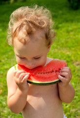 cute boy eating water melon outdoors