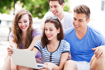 Young people with laptop outdoors