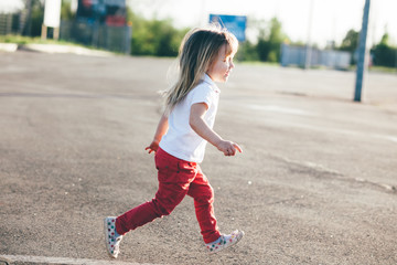Little girl running away on the road