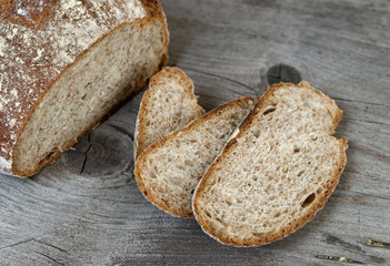 Sliced brown bread on wooden table.