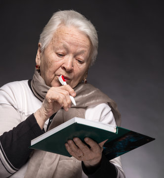 Senior woman writing notes in a notebook