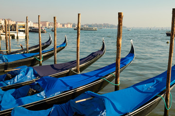 Fototapeta na wymiar Venice gondolas pier with blue gondola in Italia