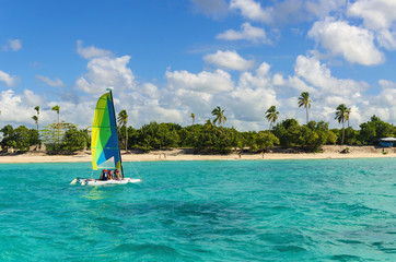 Colorful catamaran on azure water against blue sky